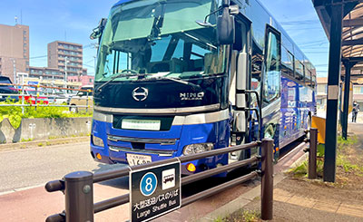 The shuttle bus departs from and arrives at the “Large Bus/Shuttle Bus Boarding Area” located just before the “East Exit Connecting Passage.”